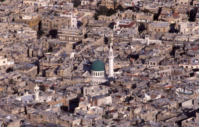 View above Damascus, Syria: roof tops, TV aerials, central green domed mosque