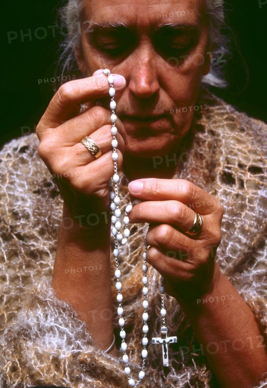 Woman using rosary beads