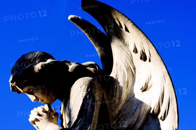 Angel praying for the dead in a cemetery