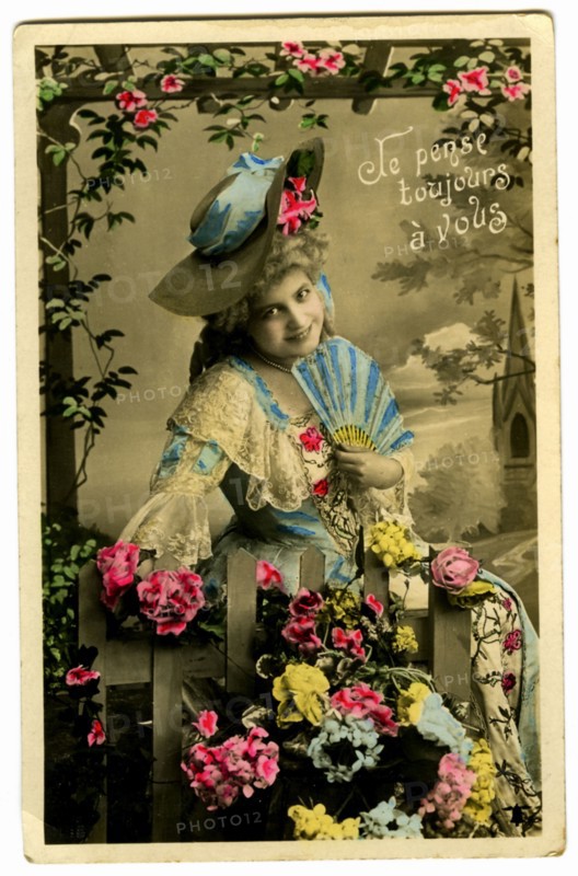 Postcard with a woman among flowers