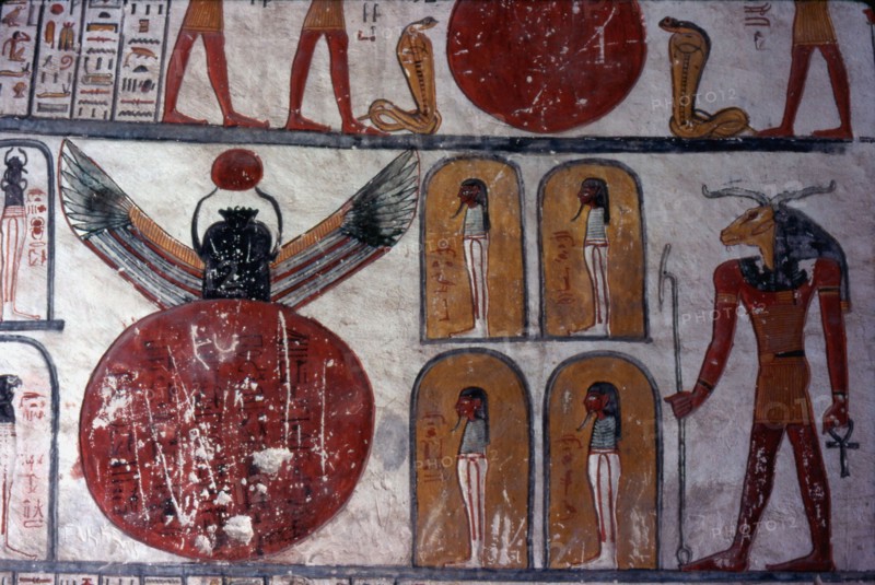 Tombe de Ramsès VI. Dieu à tête de bélier se tenant devant 4 chapelles avec une momie, et un large disque duquel sort un scarabée ailé