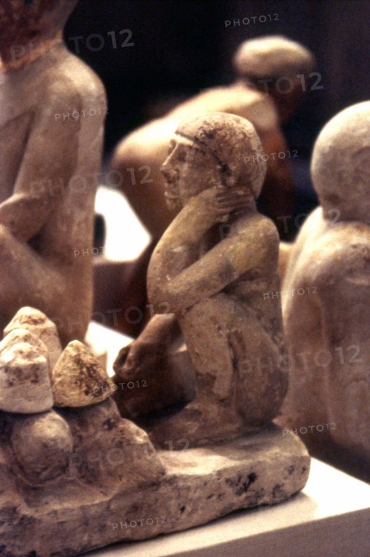 Man kneeling before loaves of bread