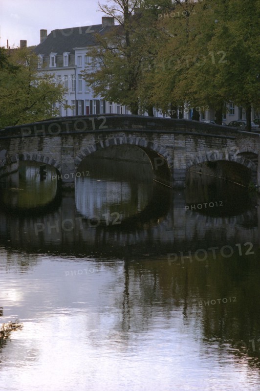 Bruges. Quai et canal de la ville médiévale, façades d'hôtels particuliers, au coucher du soleil, en automne