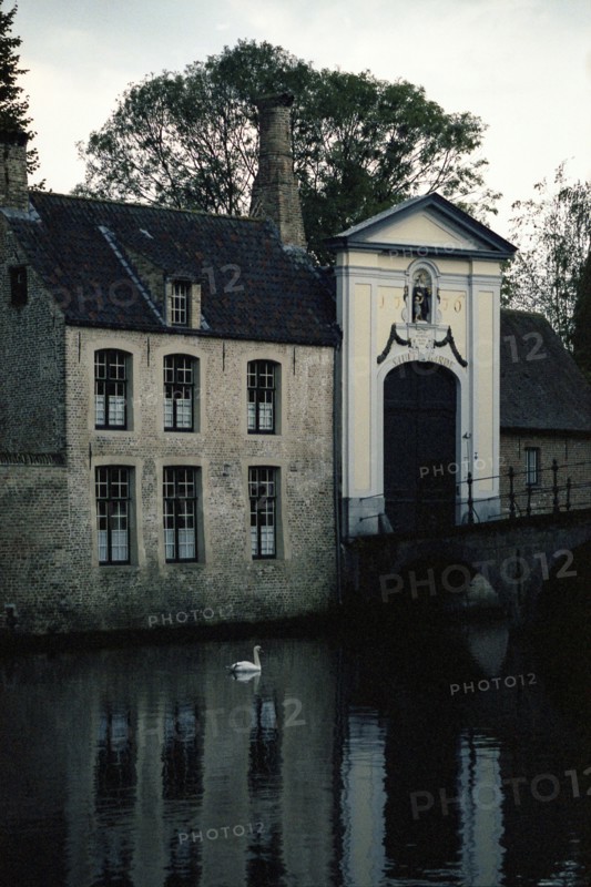 Bruges. Façade de l'entrée du Béguinage (Begijnhof) 1776 sur le canal, en automne à la tombée du jour, le soir