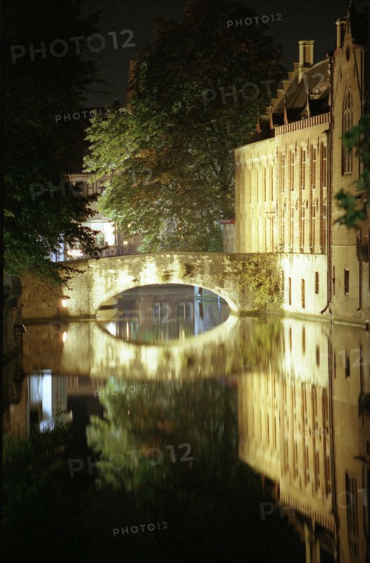 Bruges de nuit : maisons sur le canal, pont et quai, reflets dans le canal, en automne
