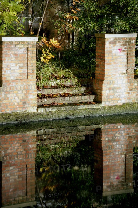 Bruges de nuit : murs de briques et escalier se reflétant dans le canal en automne, Quai du Dijver