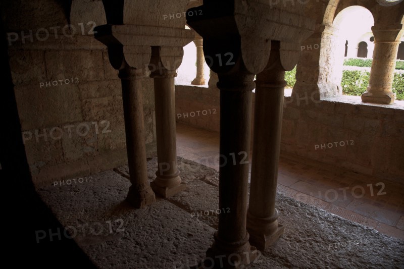 Provence810 Abbaye du Thoronet, le cloître vu depuis la salle capitulaire : arcades géminées, oculus et chapiteaux, vue sur le jardin du cloître