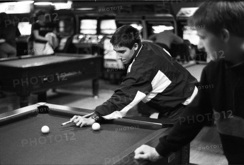 Two young people playing pool in a games arcade, with arcade machines in the background. Castlebar, County Mayo, Ireland.
2000