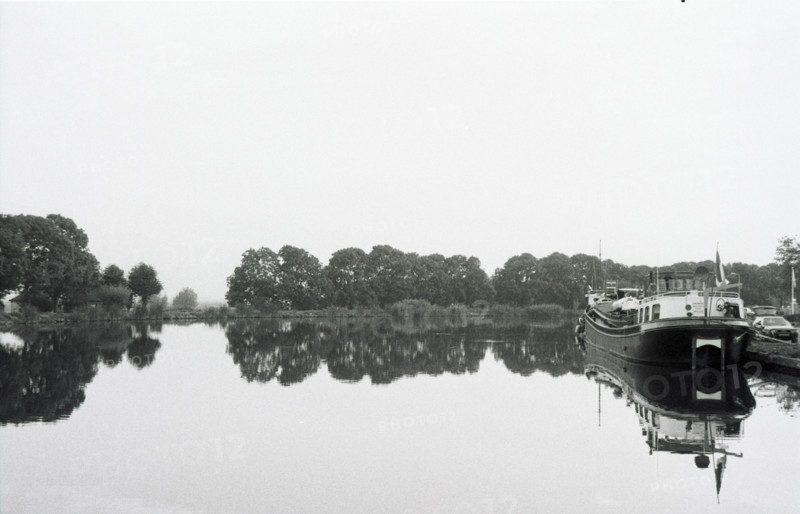 Berge boisée se reflétant dans l'eau calme de l'Amstel, des bateaux amarrés à droite. Pays-Bas.
2000