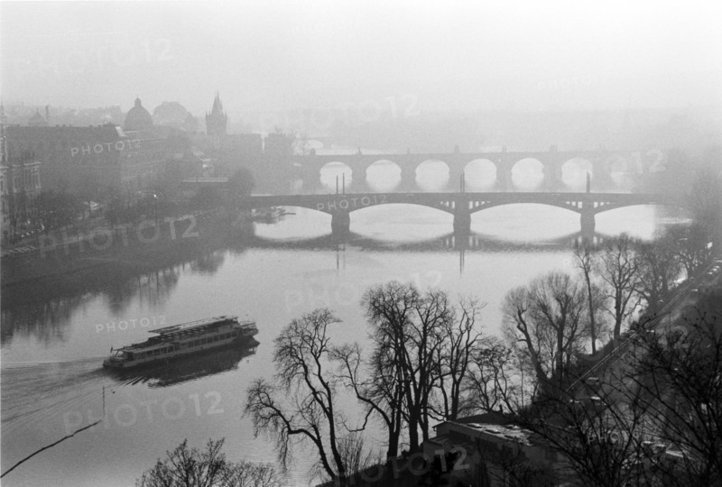 Brume sur la Vltava : un bateau sur l'eau, un pont en arrière-plan et des arbres sur la rive. Prague, République tchèque.
2001
