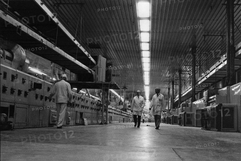 Ligne de cuisson de biscuits dans une usine, deux ouvriers marchant au centre de la halle. Tallaght, Dublin, Irlande.
1980
