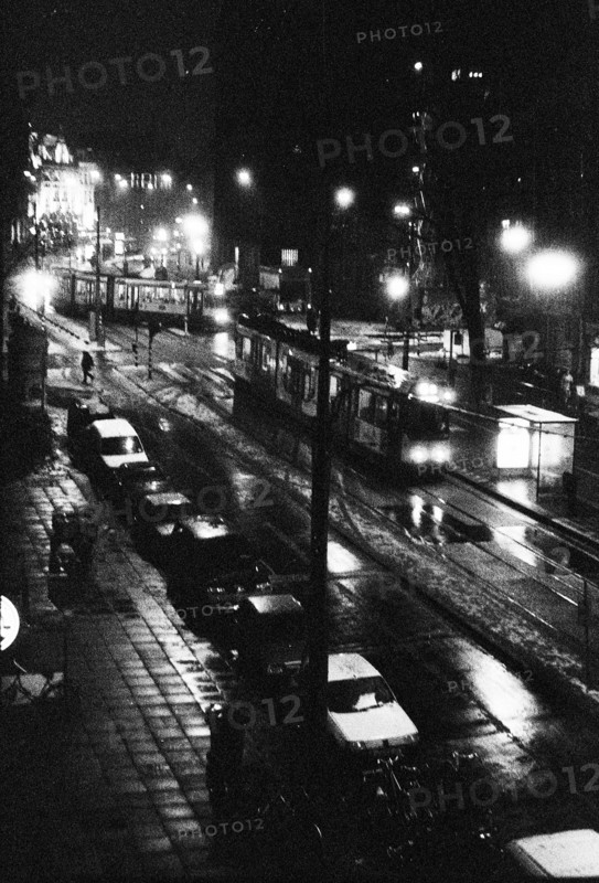 Street lit up at night, with cars driving by and reflections of light on the road surface. Amsterdam, Netherlands.
2000
