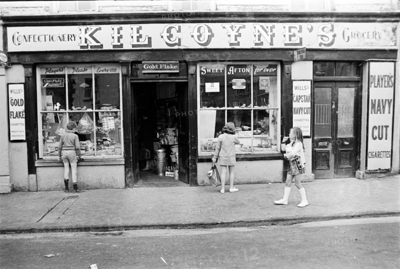 Enfants regardant la vitrine d'une épicerie en Irlande