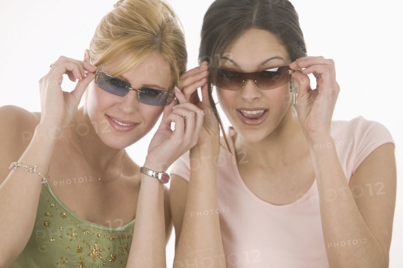 Women putting on sunglasses.