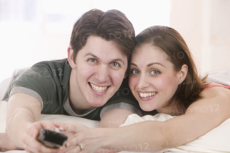 Smiling couple with remote control.