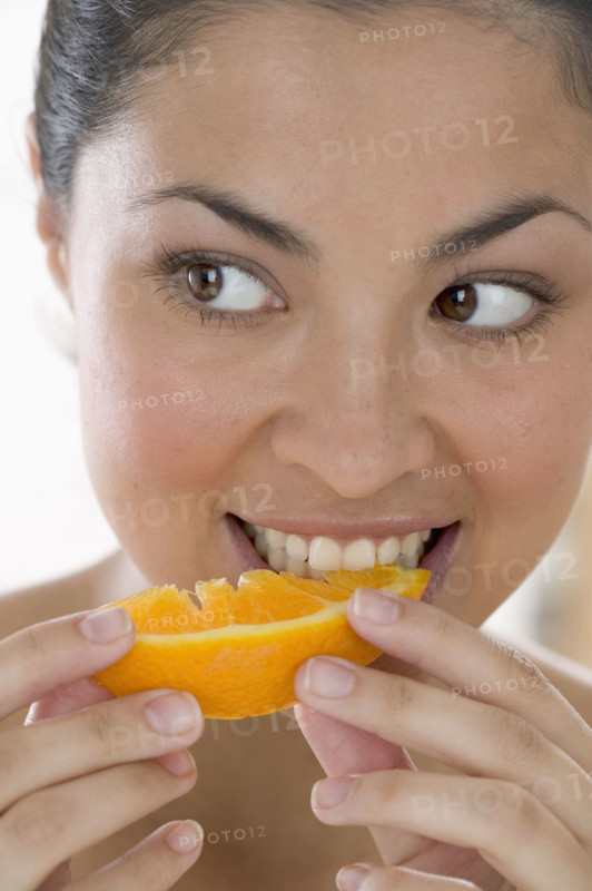 Woman eating orange.