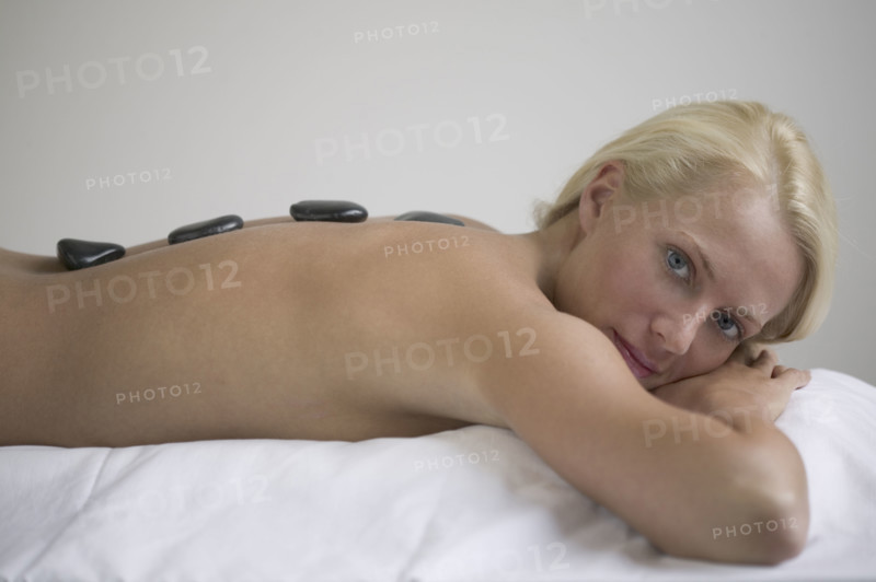 Woman receiving a hot rock treatment.