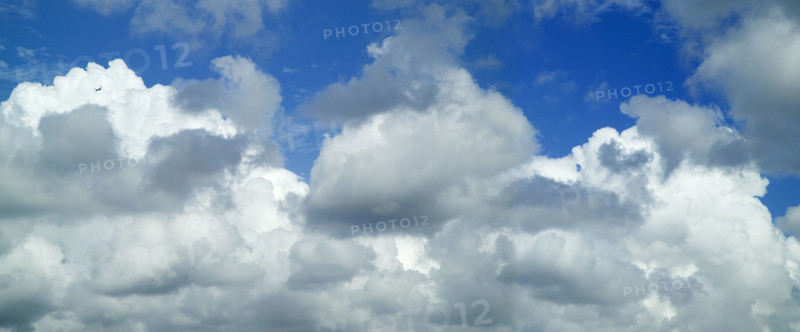 Puffy white clouds against a blue sky.
