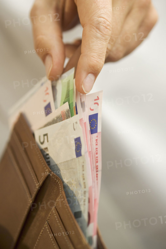 Man removing Euro bills from his wallet.
