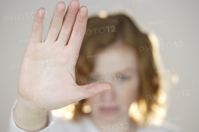Redhead with flat palm raised.