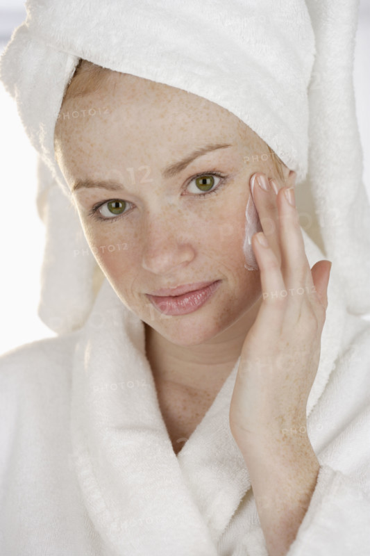 Woman applying face cream.