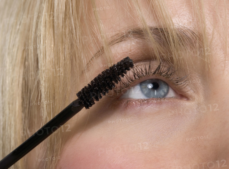 Woman's eye with mascara brush.