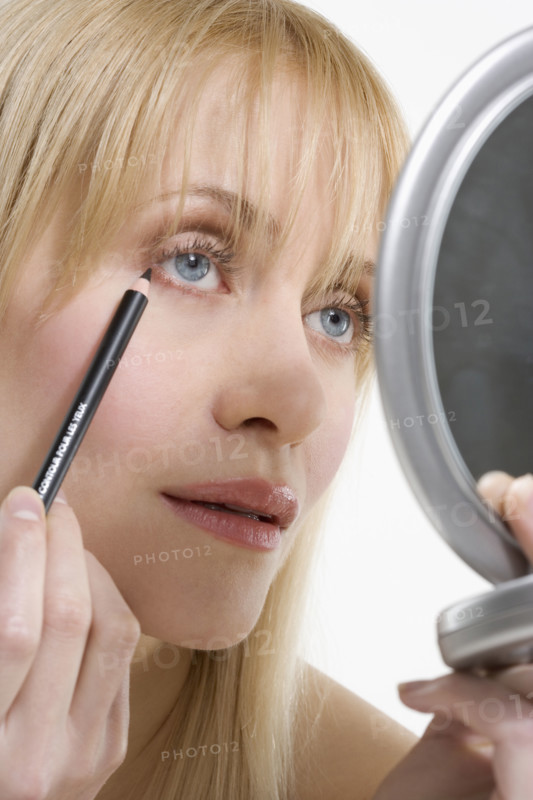Woman with mirror and eyeliner.