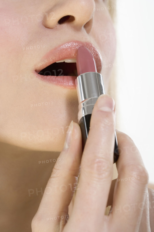 Closeup of lips with lipstick tube.