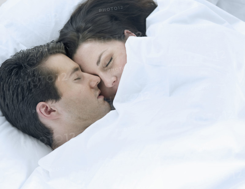 Couple asleep in bed.