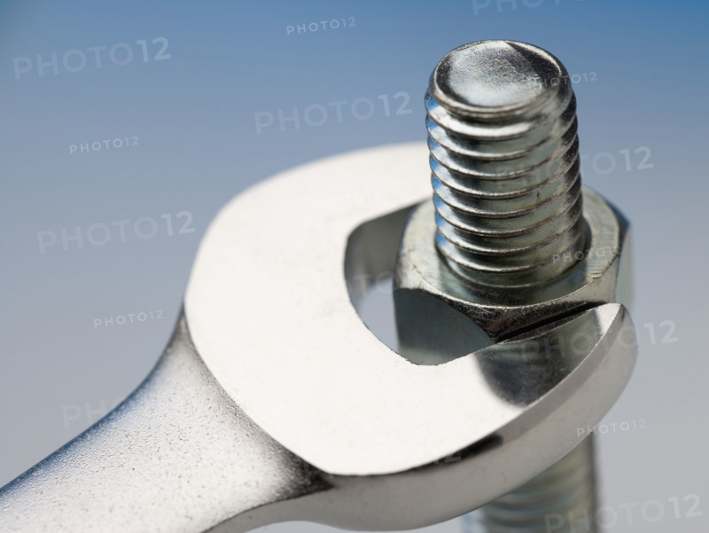 Wrench turning nut on bolt.