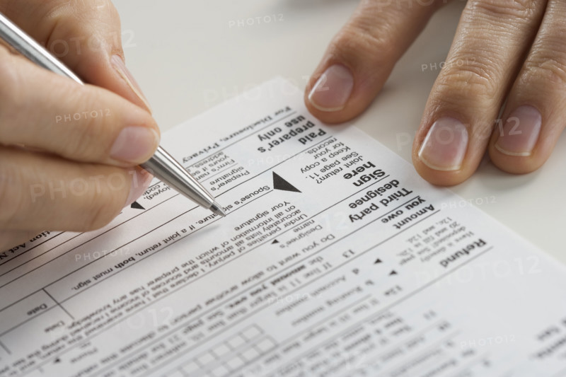 Closeup of hands with tax form.