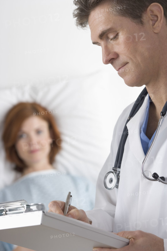 Doctor taking notes with patient.