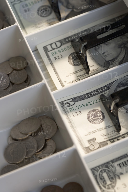 U.S. bills and coins in cash register.