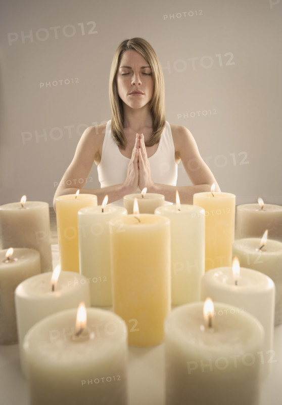 Woman meditating by candlelight.