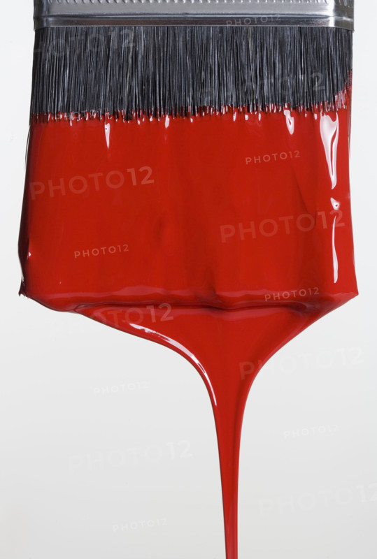Still life of paint brush with red paint.