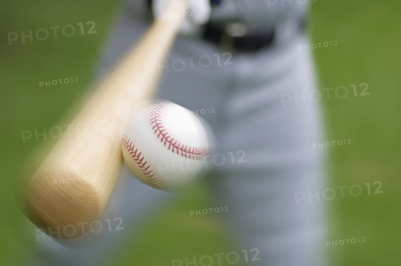 Closeup of baseball player hitting ball.