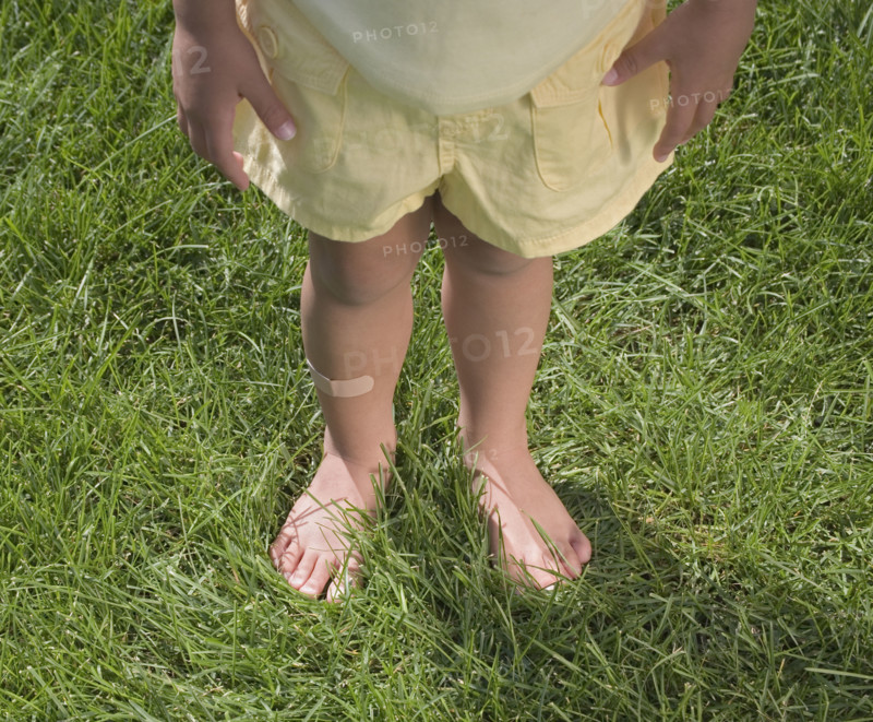 Child standing in bare feet.