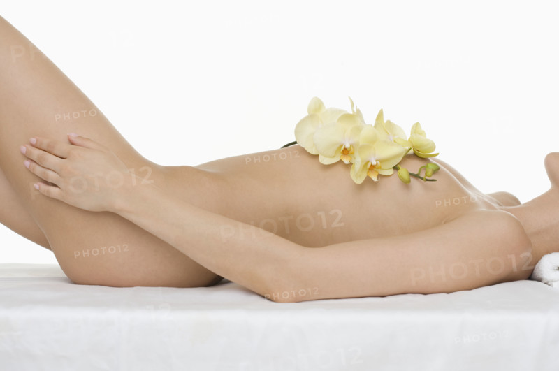 Closeup of nude woman with flowers.