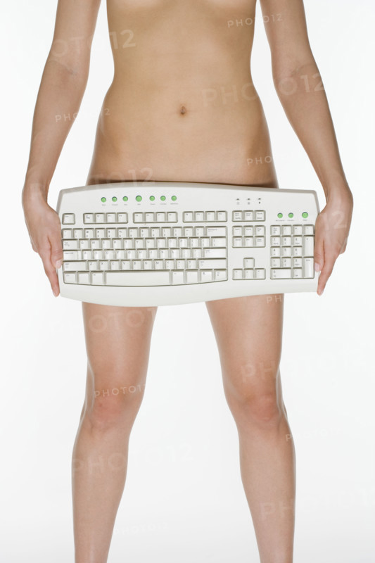 Nude female holding computer keyboard.