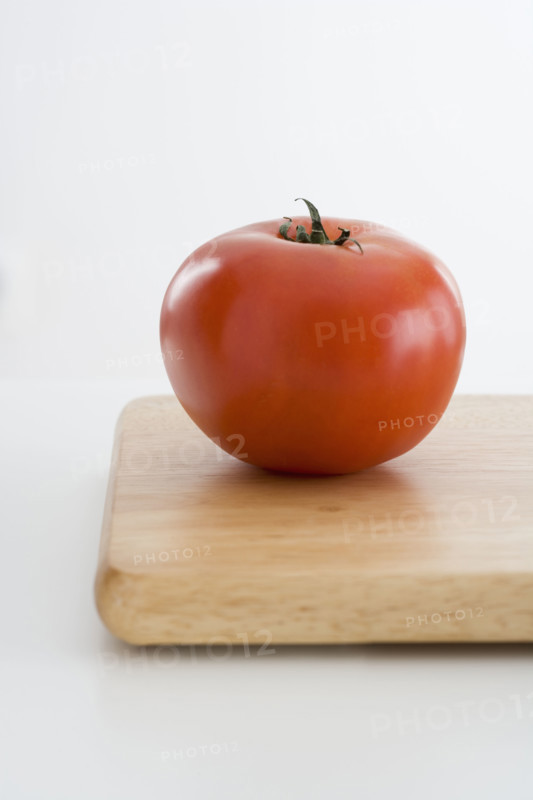Fresh tomato on cutting board.