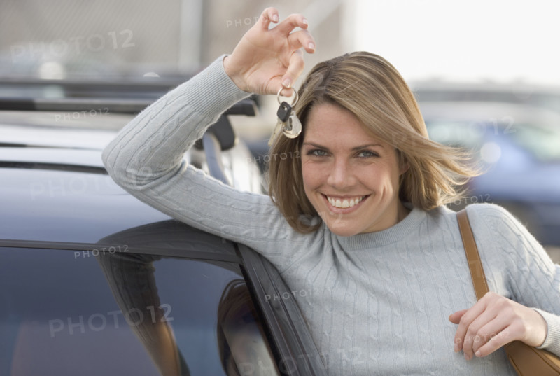 Woman holding keys to new car.