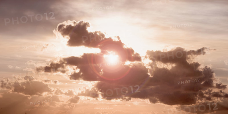Sun peeking through dark cloud.
