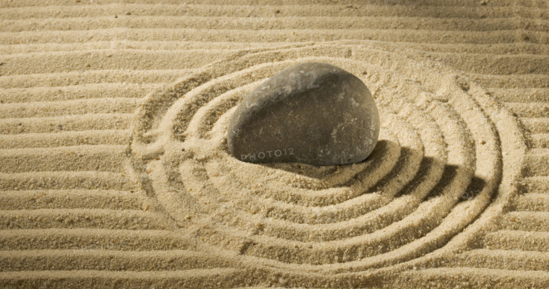 Still life of a stone on sand.