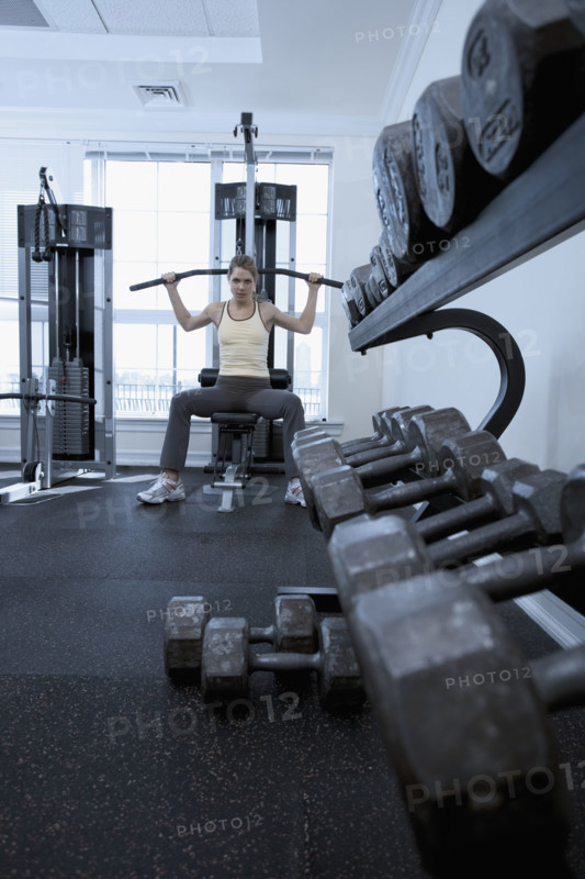 Woman working with resistance machine.