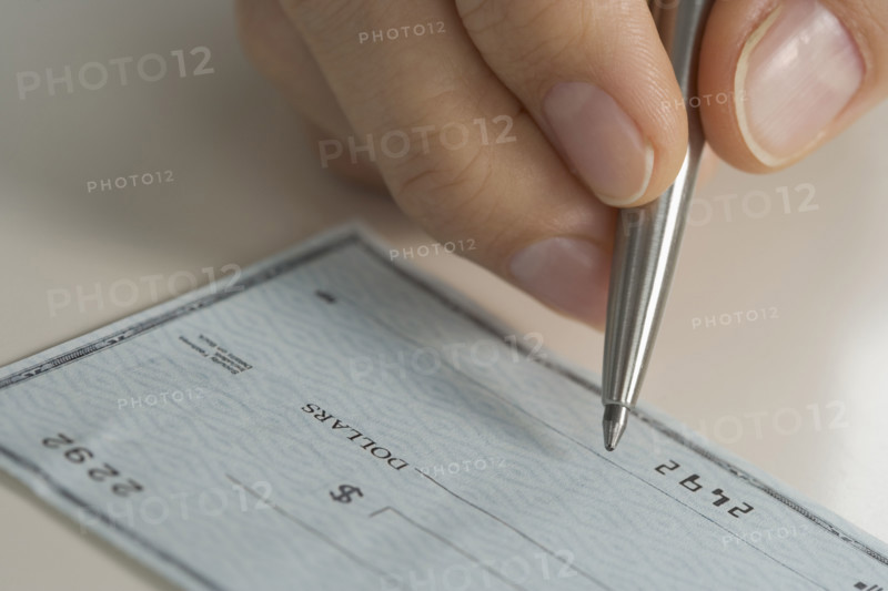 Closeup of hand writing check.