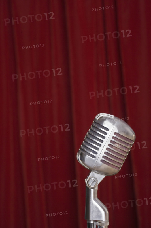Old fashioned microphone with red curtain.