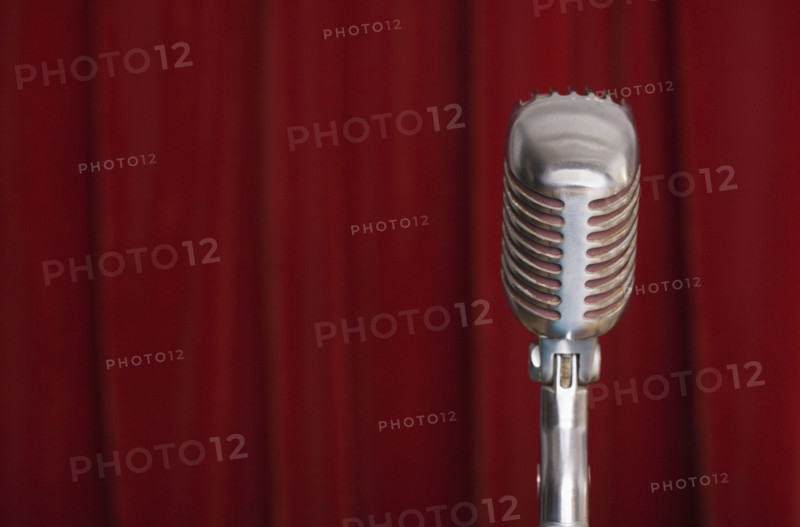 Old fashioned microphone with red curtain.