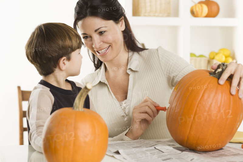 Mother and son carving pumpkins.
