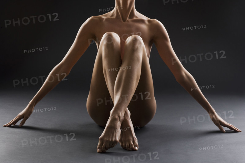 Nude female with legs crossed.