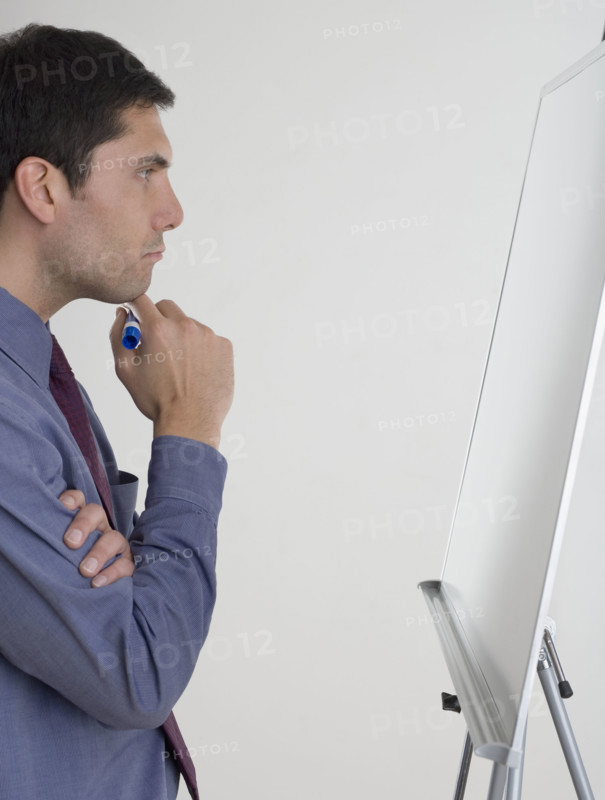 Businessman contemplating what to write.